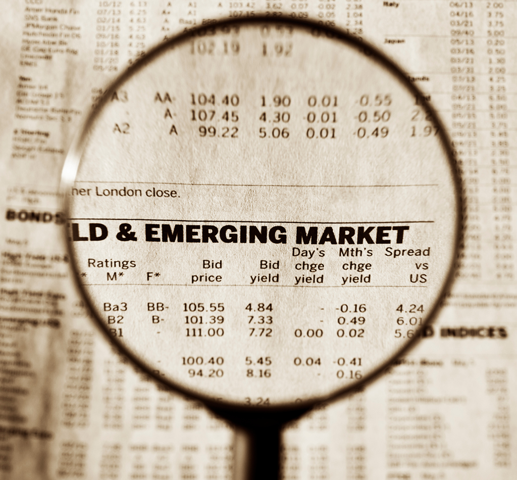 Loupe focusing on the text "Emerging Market" on financial newspaper.